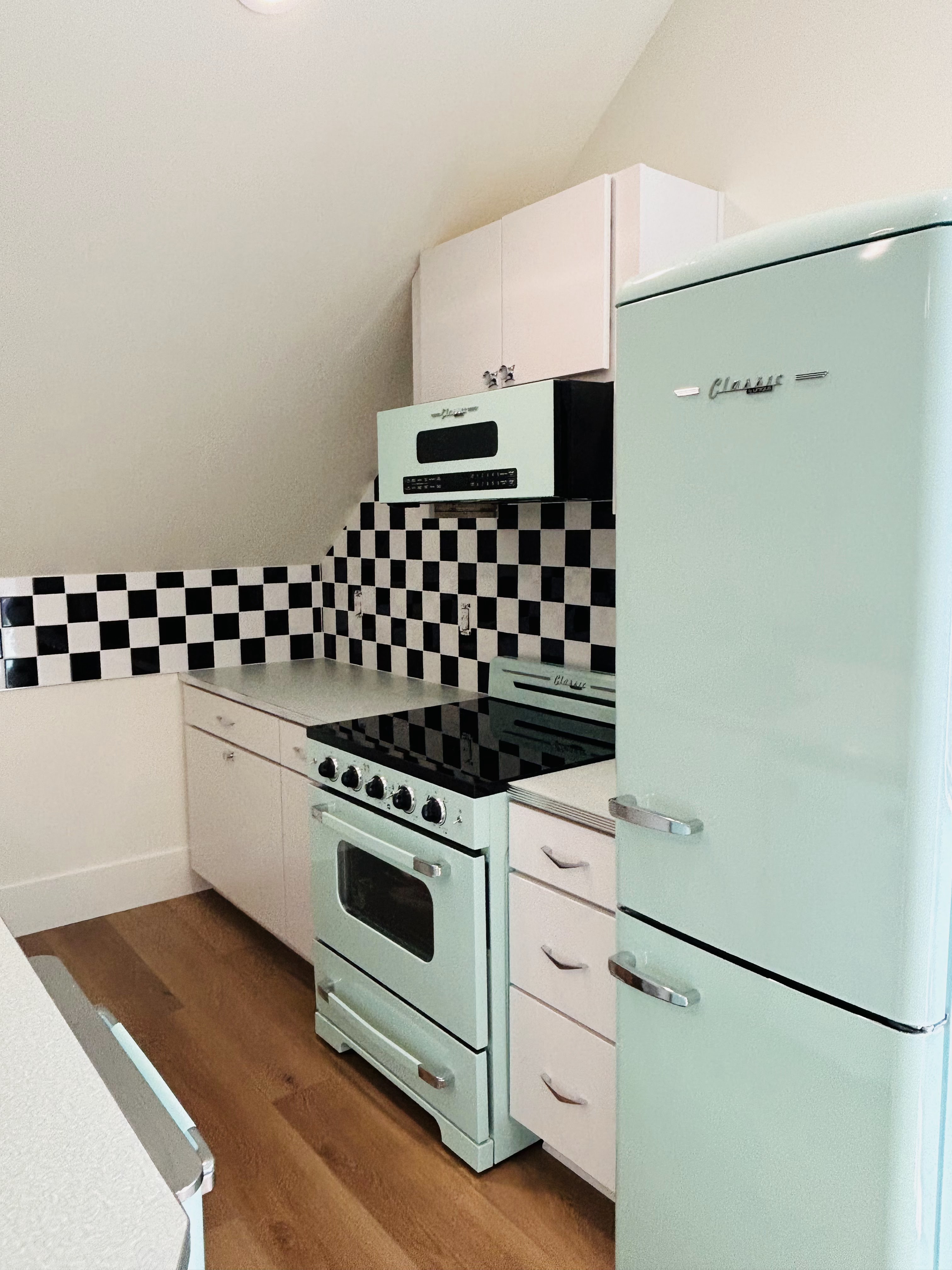 Kitchen with mint appliances and a black-and-white checkered backsplash
