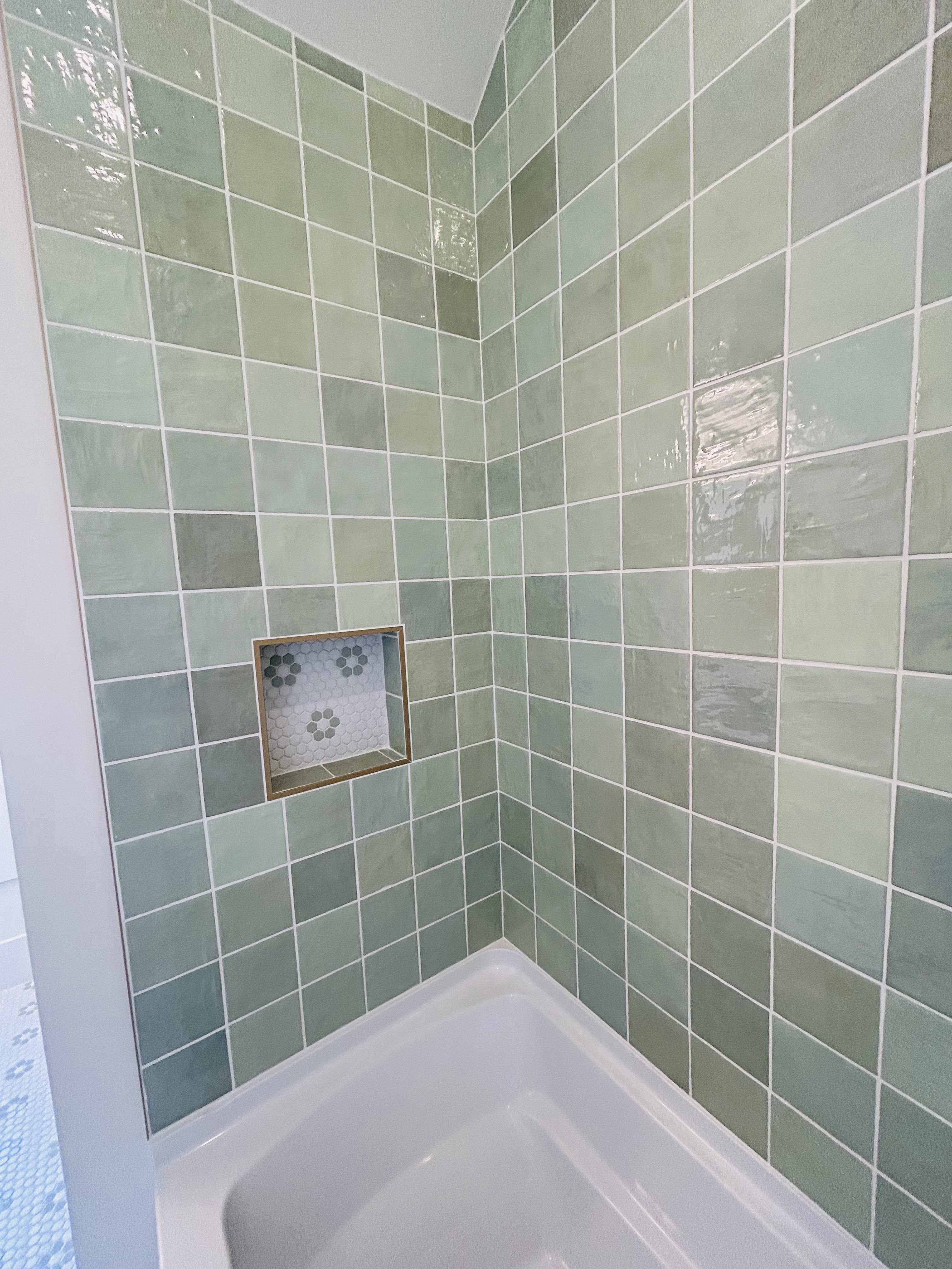 Green tile shower with a recessed hexagon-tile niche